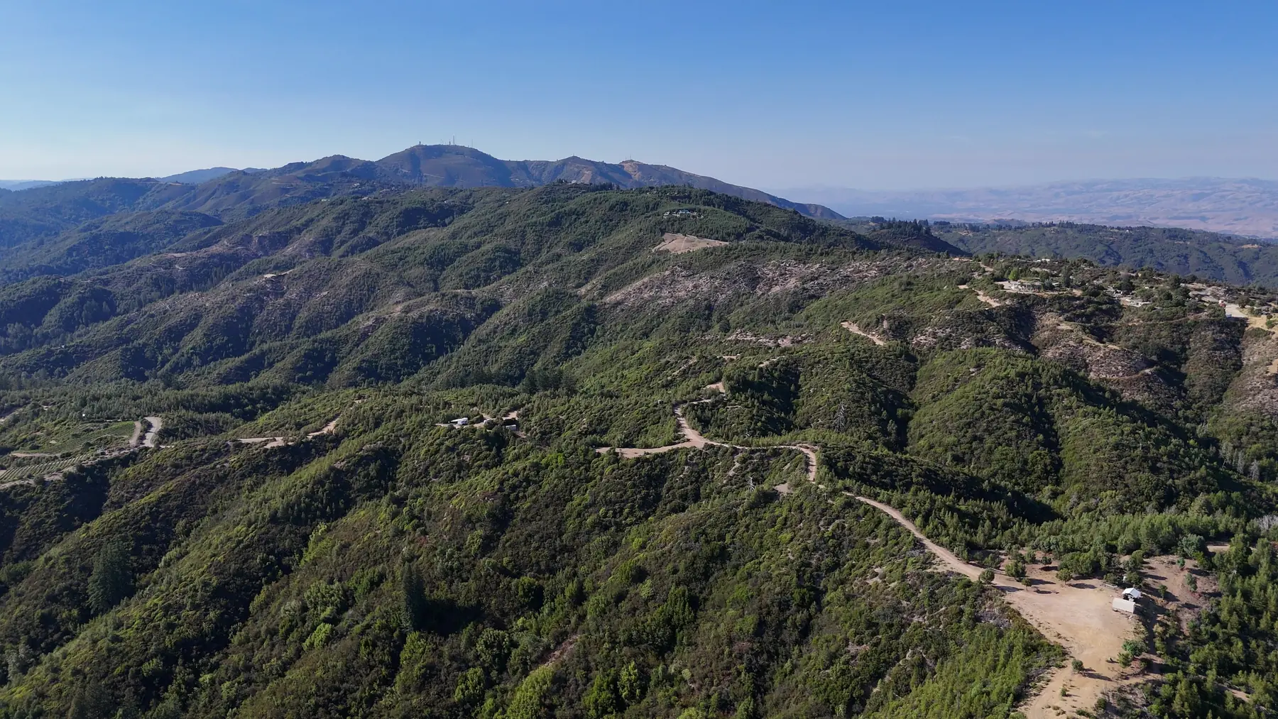 Aerial view south across the forested ridges of 2033 Eureka Canyon Road toward the Monterey Bay horizon